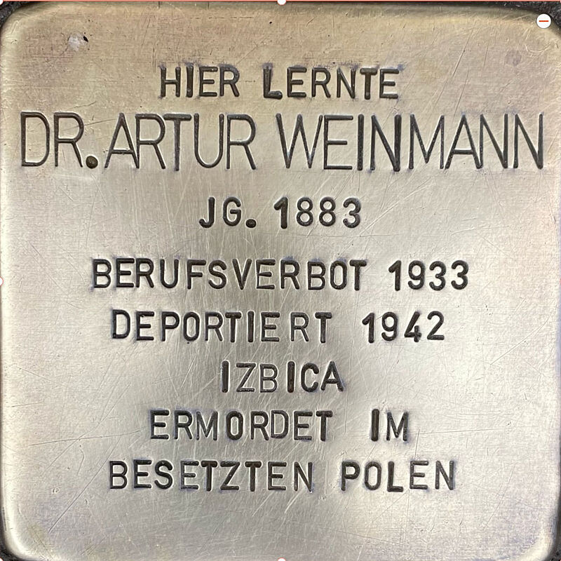 Arthur Weinmann (geboren am 14.5.1883 in Opladen, ermordet in Izbica, mit Wirkung vom 8.5.1945 für tot erklärt) besuchte die Kreuzgasse und studierte dann Jura in Bonn und wurde 1914 Amtsgerichtsrat in Krefeld und später Landgerichtsrat. Er war ein geschätzter Verfasser juristischer Literatur. Er gab seit 1924 eine juristische Zeitschrift heraus, durfte aber ab 1933 nicht mehr als Herausgeber fungieren oder unter seinem Namen publizieren.  Er war verheiratet und hatte einen Sohn. Bis zu ihrer Deportation waren Artur und Alice Weinmann in Krefeld gemeldet. Sie wurden von Krefeld aus am 18. April 1942 nach Belzecdeportiert und dort ermordet.  Quelle: Der gesamte Text fußt auf Informationen des Eintrages über Artur Weinmann in Wikipedia, Informationen des NS-Dokumentationszentrums Köln, den Einträgen in Yad-Vashem & Arolsen-Archives.