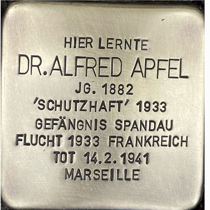 Alfred Apfel (geboren am 12.3.18882 in Düren, umgekommen am 14.2.1941 in Marseille) war Sohn des Arztes Simon Apfel und dessen Ehefrau Rahel. Nach dem Abitur an der Kreuzgasse studierte Alfred Jura in Köln und Berlin und ließ sich nach 1918 in Berlin nieder und eröffnete eine Kanzlei. Zu seinen Mandanten gehörten mehrere Prominente der Berliner Gesellschaft wie George Grosz und Carl von Ossietzky. Mit diesem Engagement und der Tatsache, dass er außerdem als Strafverteidiger einen  Kommunisten verteidigte, der den NS-Sturmbandführer Horst Wessel erschossen hatte, machte er sich die Nationalsozialisten zum Feind. Alfred Apfel wurde daher schon am 27. Februar 1933 von ihnen in sogenannte Schutzhaft genommen und floh nach der Freilassung sofort nach Frankreich. Er stand auf der ersten prominenten Liste der sogenannten „Vaterlandsverräter“ zusammen mit der damaligen demokratischen Politprominenz. Die Verfolung, Flucht und ständige Angst im Exil, doch noch an die Nationalsozialisten augeliefert zu werden, schwächten seine schon angegriffene Gesundheit. Im Februar 1940 wurden die zwei prominente Sozialdemokraten Rudolf Breitscheid und Rudolf Hilferding von der französischen Polizei festgenommen und nach Deutschland ausgeliefert, Alfred fürchtete ein ähnliches Schicksal und brach kurz danach bei dem Versuch, doch noch ein rettendes Visum zu erhalten, nach einem Herzanfall zusammen und verstarb. Er wurde 58 Jahre alt.  Quelle: Der gesamte Text fußt auf Informationen im Gedenkbuch der Kreuzgasse, Informationen des NS-Dokumentationszentrums Köln, den Einträgen in Yad-Vashem & Arolsen-Archives.