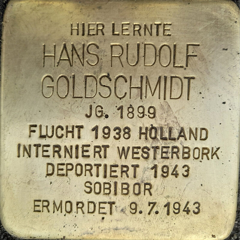 Hans Rudolf Goldschmidt, geboren am 18.1.1899, besuchte die Kreuzgasse nachweislich 1910/11. Auch sein älterer Bruder Ernst war Kreuzgässer. Ihr Vater, Josef Goldschmidt, war ein renommierter Goldschmied, der zusammen mit seinem Bruder ein Juweliergeschäft genau gegenüber vom Dom besaß. 1938 floh Hans Rudolf in die Niederlande, nach Amsterdam. Am 20. Juni 1943 wurde er während einer Razzia gefangengenommen und nach Westerbork deportiert. Von dort aus wurde er dan am 6. Juli 1943 nach Sobibor deportiert, wo er umkam.